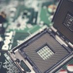 Detailed view of a CPU socket on a green motherboard, showcasing microprocessor technology.